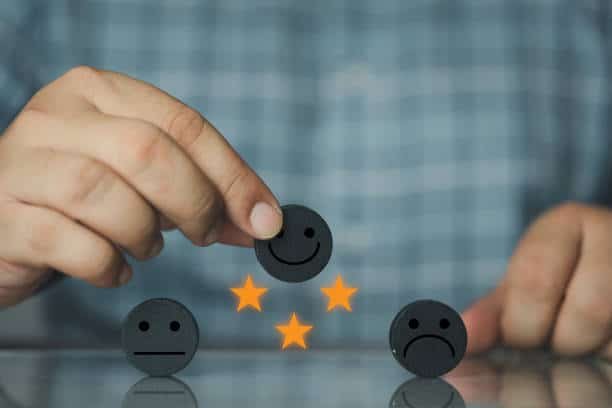 a person putting a smiley face on a stack of black round objects